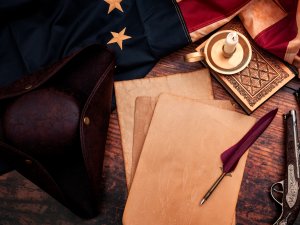 Aged papers on a table with a pen and American flag