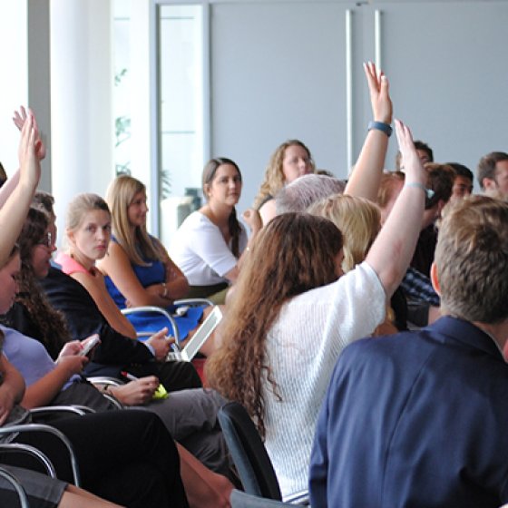 Students in a classroom raising their hands