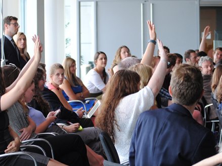 Students in a classroom raising their hands