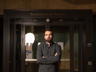 Stanford Law School student Nicholas Wallace stands before the school entrance