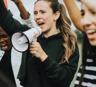 Students rallying and young woman holding megaphone