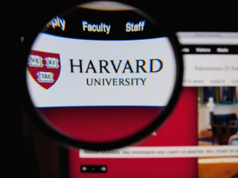 Photo of Harvard University homepage on a monitor screen through a magnifying glass
