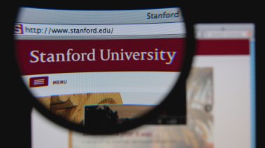 Photo of Stanford University homepage on a monitor screen through a magnifying glass 