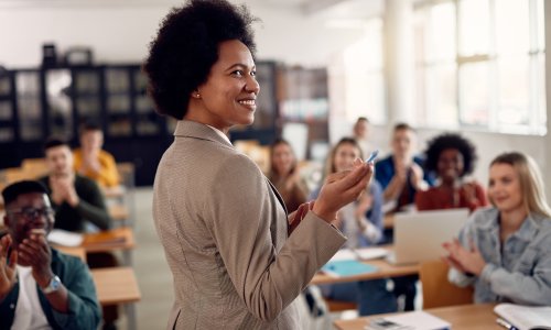 Professor receives applause from students while lecturing them in the classroom