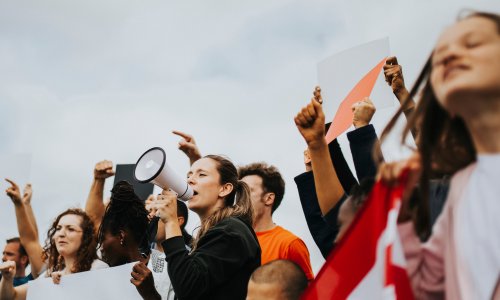 protesters marching and one holding a megaphone