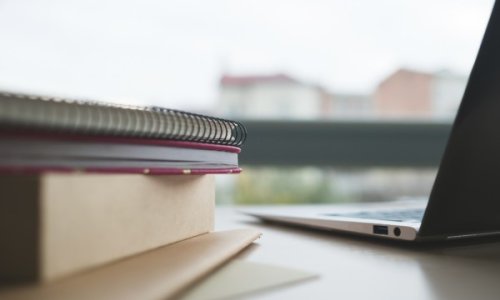 open laptop computer and notebooks on a table